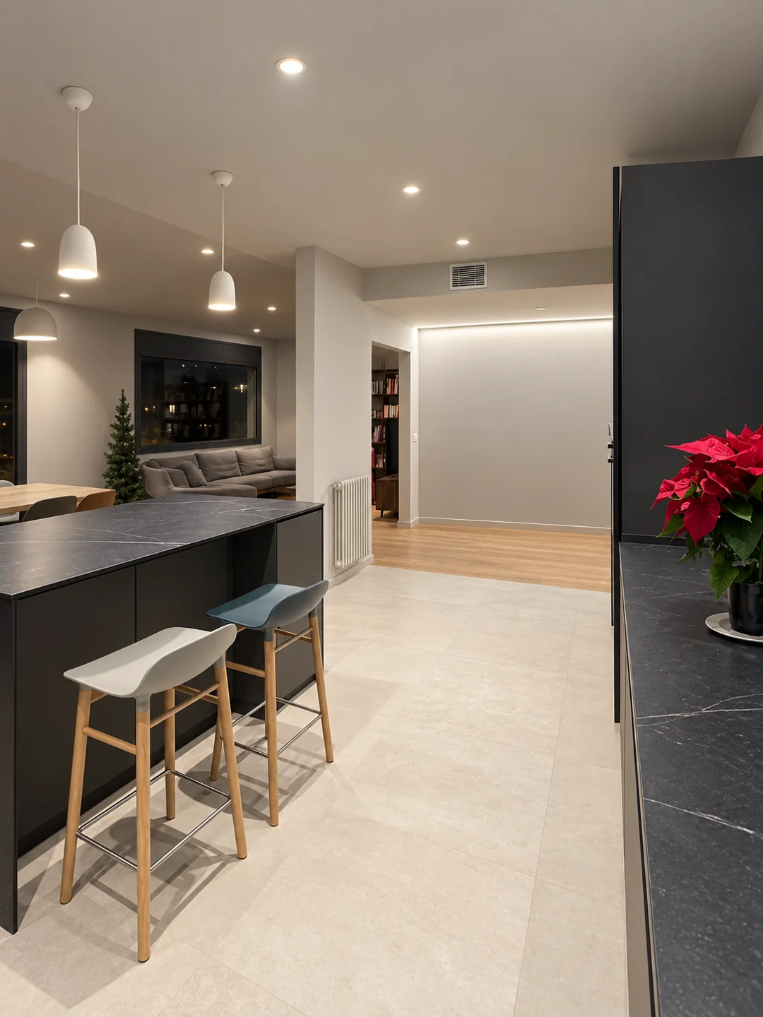 Cocina de Balmes abierta al espacio de día, con una barra y taburetes de madera