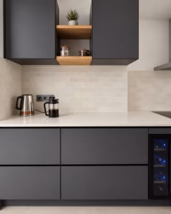 Muebles de cocina oscuros con encimera clara y nicho abierto de madera.