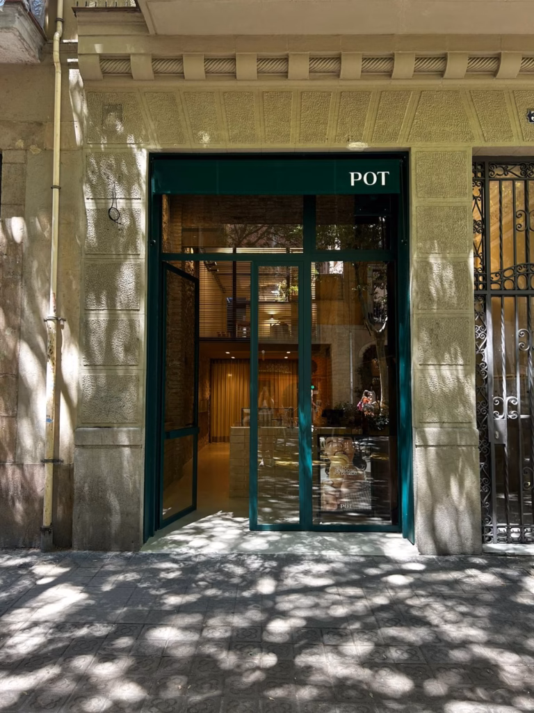 Fachada de la heladería POT en la calle Parlament de Barcelona, con acceso acristalado y carpintería verde