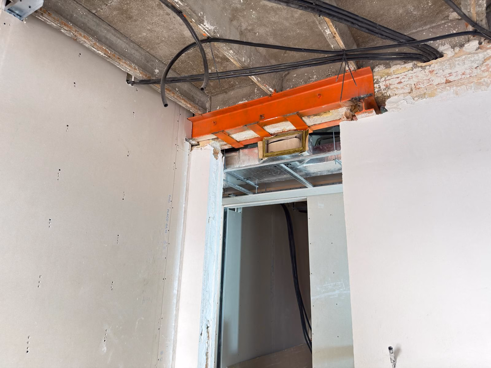 Perfil metálico sobre un paso interior durante la reforma de una vivienda en Barcelona.